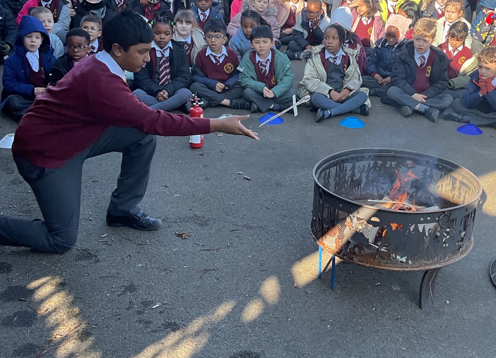 Child throwing a palm cross into the fire pit